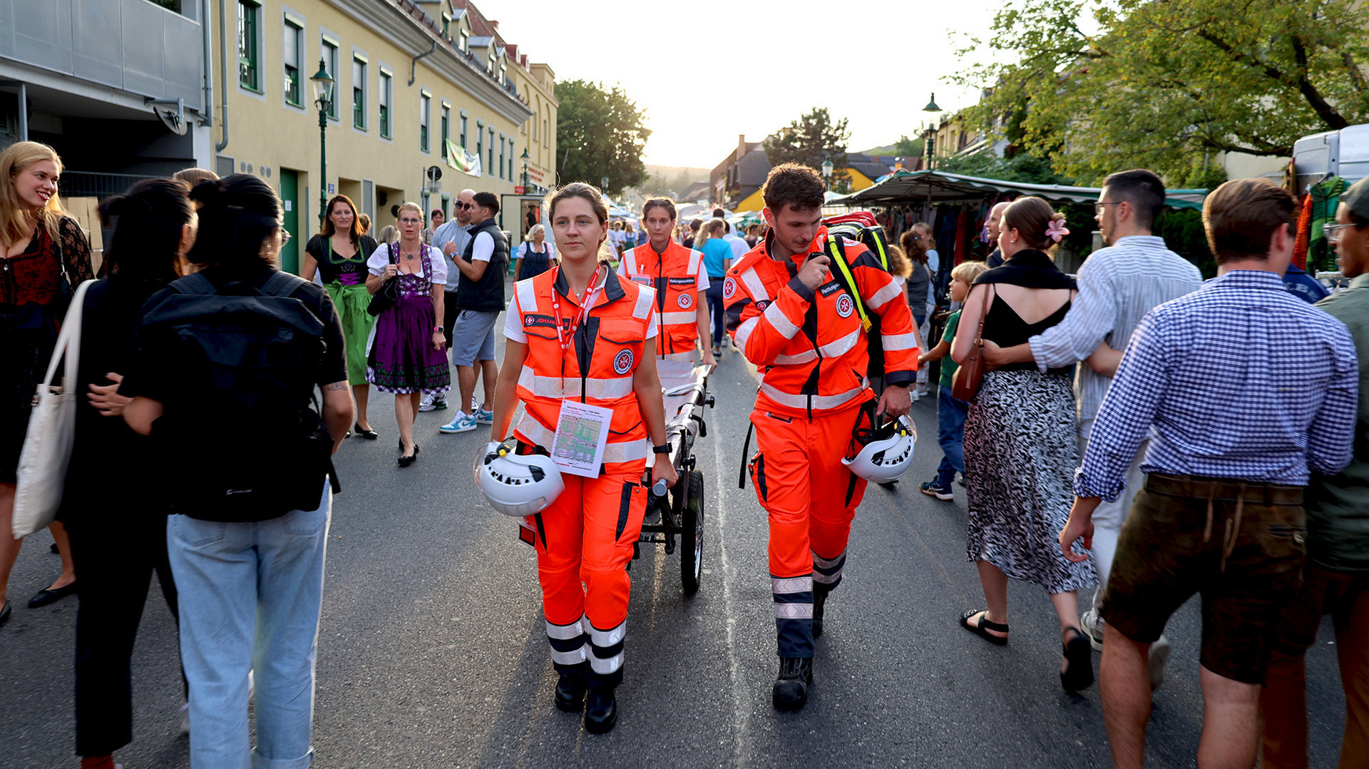 (c) Johanniter/R. Olivares Alba Ein Sanitätsteam geht durch die Menge beim Kirtag.